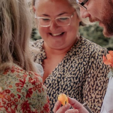 Danielle laughing as a light-up plastic ring is handed over during a ceremony